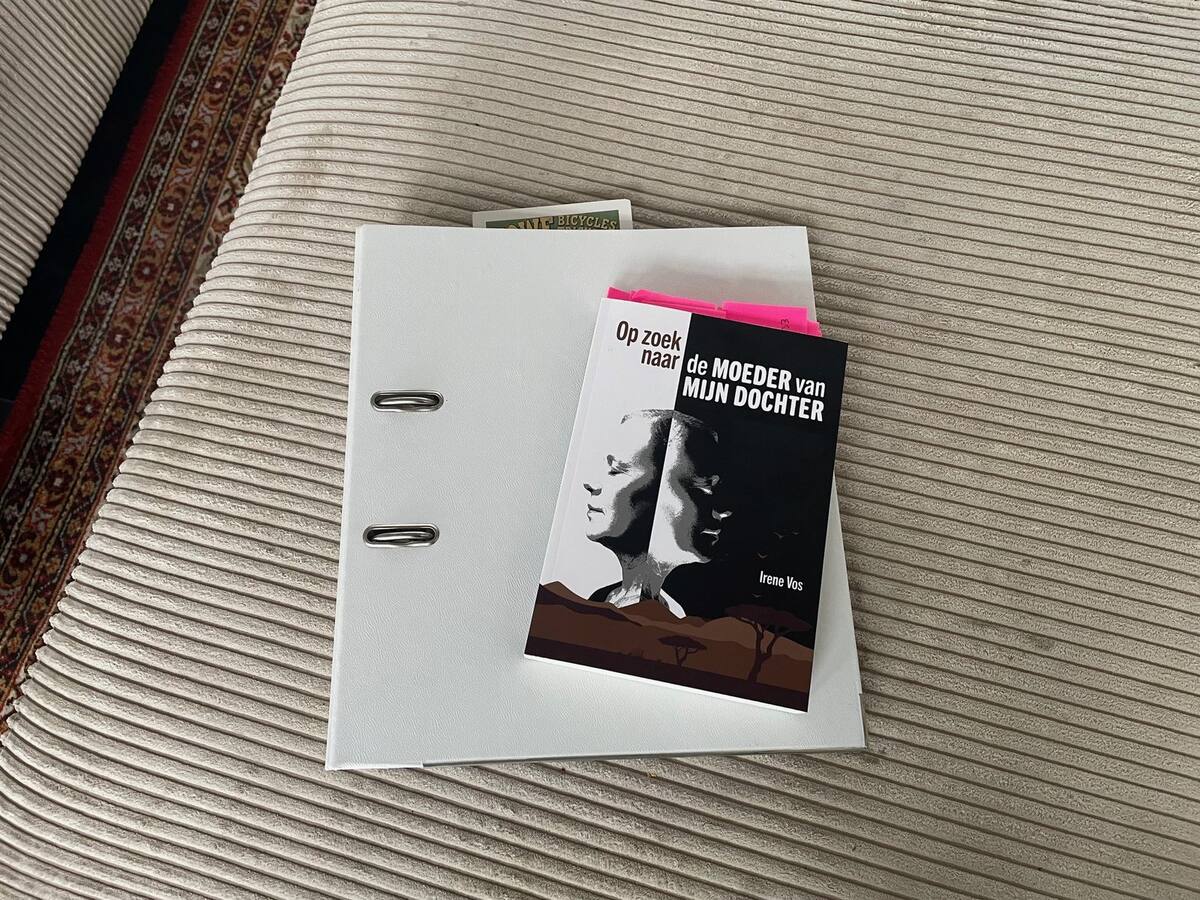 Witte klapper met het manuscript, met daarop het gedrukte boek